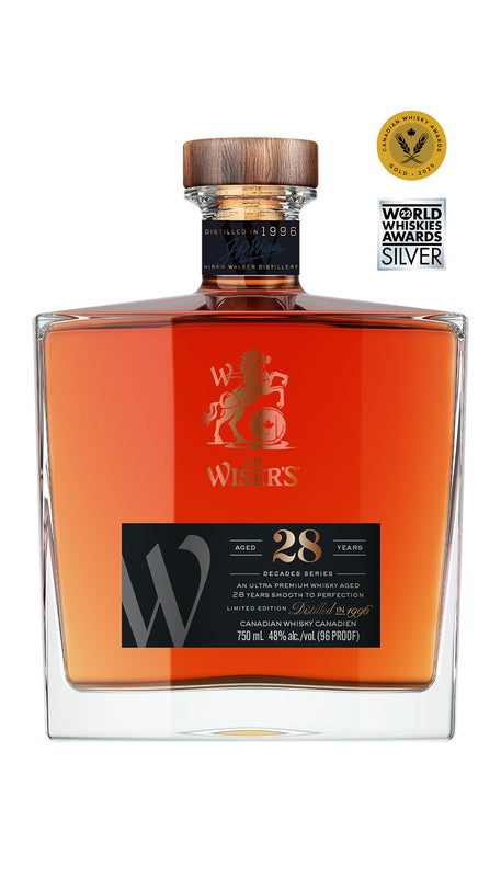 J.P. Wiser’s 28 Year Old Canadian Whisky 750ml bottle on a white background, featuring a clear glass bottle with a wooden cap and a premium black and gold-accented label. The label highlights the 28-year aging and Canadian whisky branding. The whisky inside has a deep golden hue. A rare, collectible Canadian whisky crafted in Ontario, celebrating the spirit of the 1990s with notes of fragrant honey, delicate fruit, and wholesome rye.
